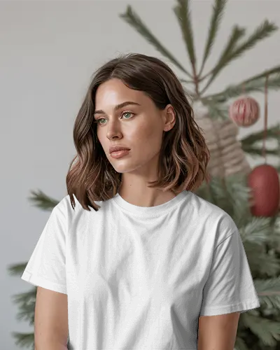 Christmas Tshirt Mockup Female Model In Cozy Tree Setting Soft Natural Holiday Light