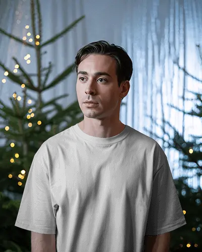 Christmas Tshirt Mockup Male Model In Among Lit Trees Warm Winter Ambience Calm Scene