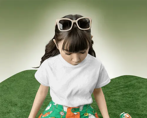 Kids Fashion Tshirt Mockup Girl Looking Down In Playful Studio Green Grass Inspired Backdrop