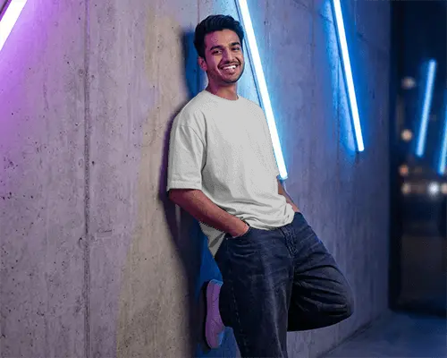 Casual Loose Fit Tshirt Mockup For Men Standing Against Textured Wall With Neon Lights
