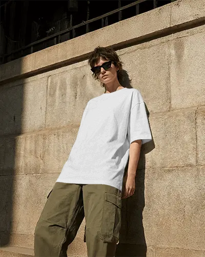 Urban Street T Shirt Mockup Female Model Leaning Against Stone Wall Concrete