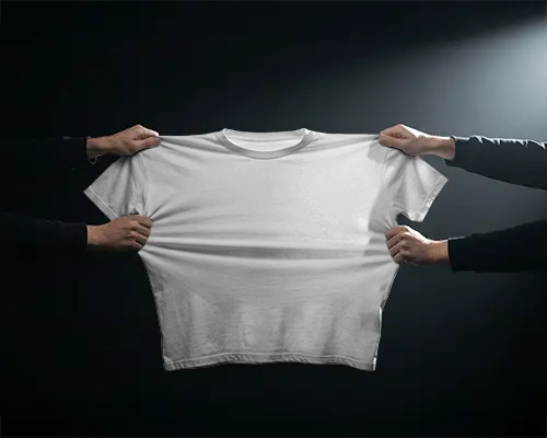 Hands Stretching T Shirt Mockup Fabric Pulled Wide In Dark Studio With Dramatic Spotlight