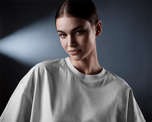 Focused Light T Shirt Mockup Female Model Smirking Under Soft Backlight