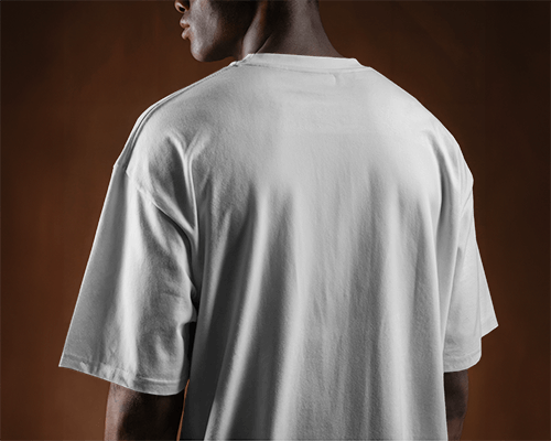 Back View T Shirt Mockup On Male Model In Moody Brown Background Showcasing Relaxed Fit