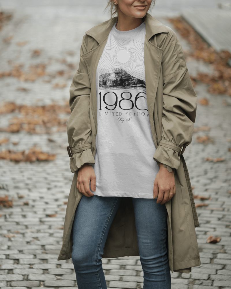 Cobblestone Walkway T Shirt Mockup Female Model Wearing Trench Coat And Jeans With Neutral Tones
