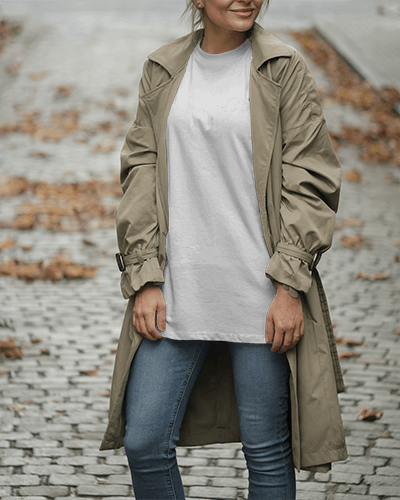 Cobblestone Walkway T Shirt Mockup Female Model Wearing Trench Coat And Jeans With Neutral Tones