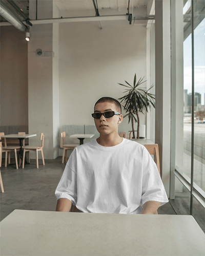 Modern Cafe T Shirt Mockup Male Model In Sunglasses Minimalist Industrial Interior Relaxed Urban Lifestyle Aesthetic 0752
