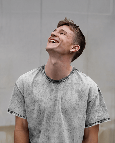 Acid Wash T Shirt Mockup Male Model Laughing And Looking Up Relaxed Urban Streetwear Vibe Natural And Candid Moment 0769