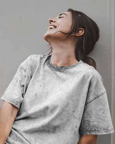 Urban Relaxed Acid Wash T Shirt Mockup Female Model Laughing In Washed Grey Tee Casual And Carefree Vibe 0772