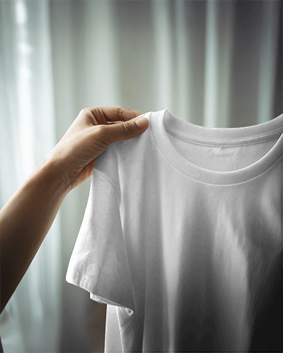 Soft Lit Blank Unisex Round Neck T Shirt Mockup Hand Holding White Tee Near Window With Sheer Curtains Cozy And Minimalist Aesthetic 813