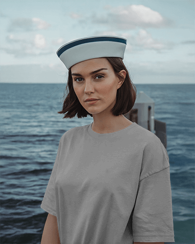 Nautical Themed Blank Women Oversized Round Neck T Shirt Mockup Female Model In Sailor Hat Standing By The Sea Maritime Aesthetic 0821