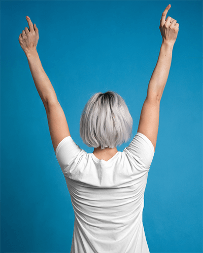 Studio Backdrop Back View Blank White Tshirt Mockup Happy Short Haired Female Model Raising Arms Against Bold Blue Background Energetic And Clean Style 0889