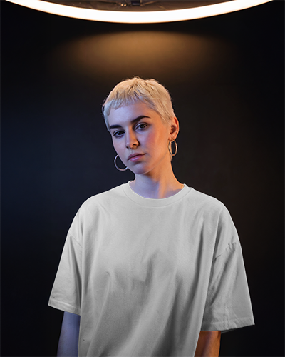 Moody Studio T Shirt Mockup Female Model Under Halo Lighting With Serious Expression Dark Background Contrasting Glow Aesthetic 0916