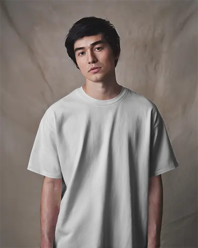 Neutral Studio T Shirt Mockup Male Model Facing Forward With Relaxed Expression Soft Textured Backdrop Clean And Minimal Aesthetic