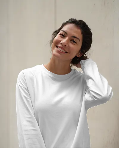 Minimal Outdoor Long Sleeve Tshirt Mockup Female Model Smiling With Hand In Hair Against Light Textured Wall Soft Natural Light And Clean Look