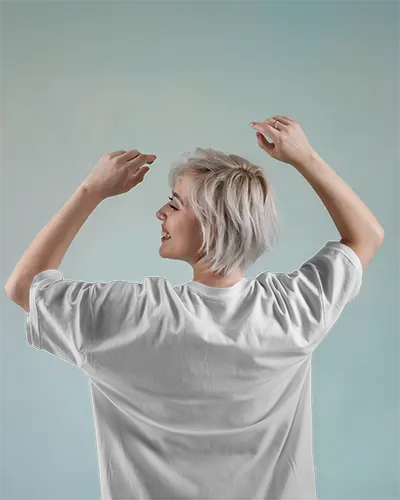 Playful Studio Backview Tshirt Mockup Female Model With Short Blonde Hair Hands Up In Motion Against Gradient Pastel Backdrop Lighthearted And Modern Style