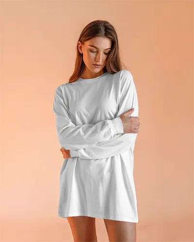 Minimalist Studio Long Sleeve Tshirt Mockup Female Model In Relaxed Pose Soft Peach Background Clean And Elegant Look