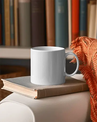 Cozy Study Mug Mockup White Ceramic Mug On Open Book With Warm Orange Scarf And Bookshelf Background Relaxed Learning Atmosphere Modern Library Mug Mockup Elegant White Mu