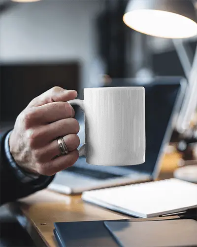 Modern Office Mug Mockup White Ceramic Mug Held By Hand In Well Lit Workspace With Notebook And Desk Lamp Functional And Aesthetic Setting