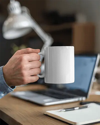 Workspace Mug Mockup White Coffee Cup With Design Space Held By Hand On Desk With Laptop And Notebook Focus On Productivity And Professional Setting