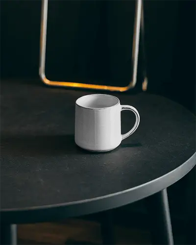 Simple Elegant Dining Room Ceramic Mug Mockup On Smooth Textured Round Table