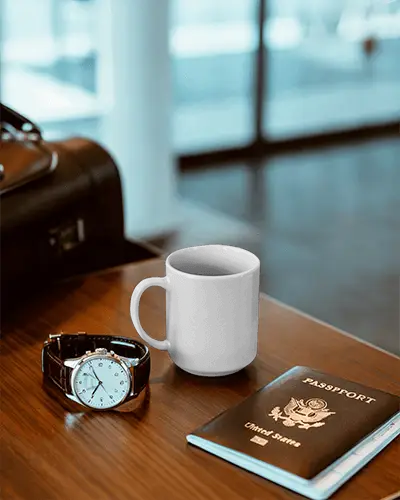 travel-accessories-with-mug-mockup-on-wooden-table-luxury-watch-and-passport