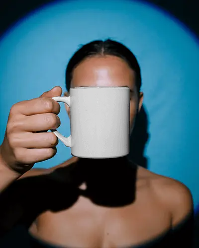 Minimalist Portrait Mug Mockup Held In Hand With Bold Shadow Lighting
