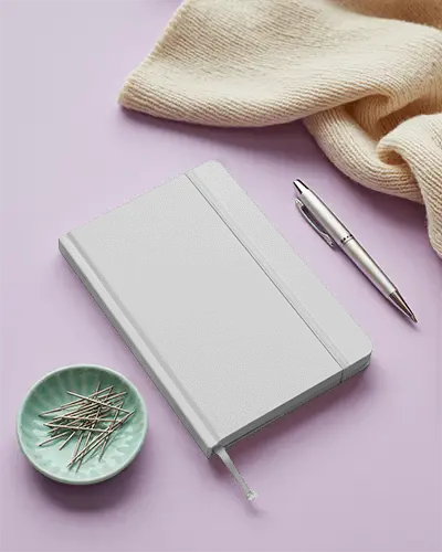 Soft Pastel Notebook Mockup With Cozy Knit Fabric And Silver Pen On Lilac Surface