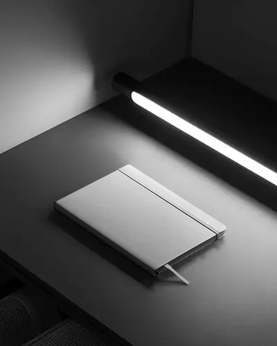 cinematic-office-notebook-mockup-with-strong-shadow-and-table-lamp-lighting-style