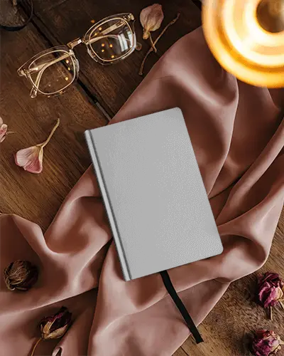 elegant-notebook-mockup-on-wooden-desk-with-pink-fabric-dried-flowers-and-glasses