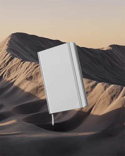 hardcover-notebook-mockup-floating-over-desert-landscape-background-for-branding