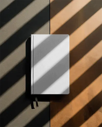 elegant-closed-notebook-mockup-on-textured-surface-with-contrasting-light-and-shadow-pattern