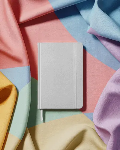 Hardcover Notebook Mockup With Ribbon Bookmark On Textured Fabric Background For Branding