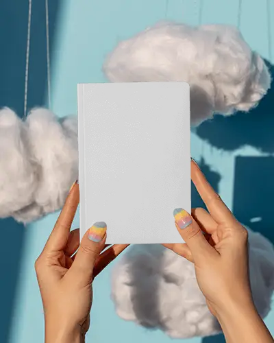 Floating Clouds Notebook Mockup Held Up Against Bright Blue Sky Inspired Backdrop