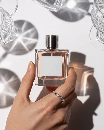 Premium Perfume Bottle Mockup Hand Displaying Square Glass Surrounded By Sunlit Crystal Shadows