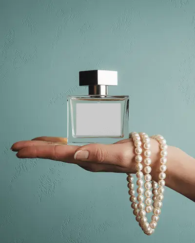 luxury-perfume-bottle-mockup-on-hand-with-pearl-necklace-against-pastel-background-elegant-style