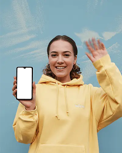 Cheerful Oneplus Smartphone Mockup Smiling Model Holding Phone In Yellow Hoodie Against Blue