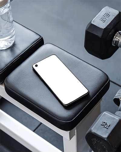 Gym Bench Smartphone Mockup On Workout Equipment With Dumbbells And Water Bottle