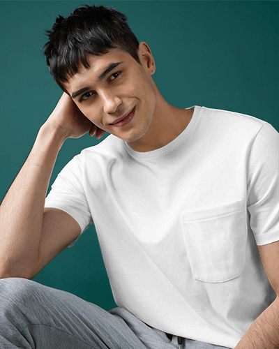 Trendy Pocket T Shirt Mockup Male Model Smiling Against Deep Green Background Relaxed And Playful Style