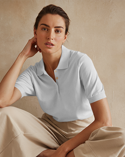 Modern Polo Shirt Mockup Female Model In Deep Teal Polo With Inspirational Design Sitting Against Textured Neutral Background Stylish And Confident Look
