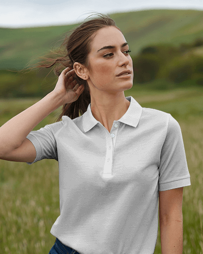 Outdoor Polo T Shirt Mockup Female Model In Windy Field Against Green Hills Natural And Relaxed Aesthetic