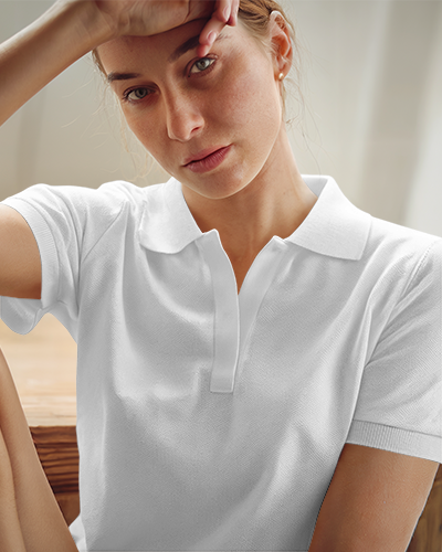 Relaxed Polo Shirt Mockup Female Model In Light Blue Polo With Daisy Design Casually Posing In Soft Natural Lighting Modern And Serene Look