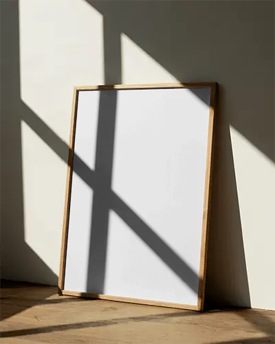 minimalist-poster-mockup-with-wooden-frame-leaning-against-wall-in-natural-light