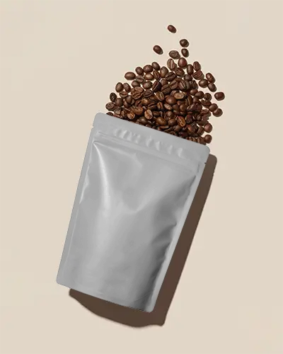 Resealable Stand Up Pouch Mockup With Spilled Coffee Beans Isolated On Light Background