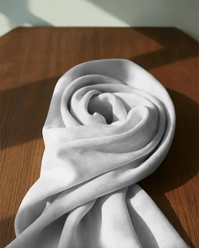 softly-styled-scarf-mockup-draped-on-table-with-shadows-and-bright-daylight-for-warm-aesthetic