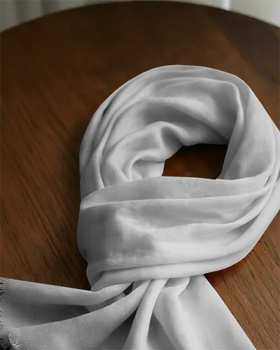 cozy-fabric-scarf-mockup-draped-over-polished-wood-surface-with-realistic-daylight-shadow
