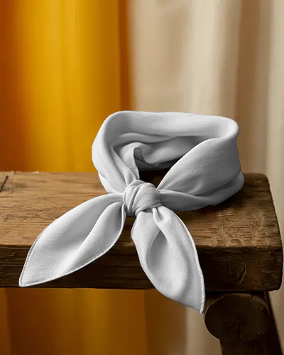 elegant-scarf-mockup-tied-knot-display-on-wooden-surface-with-curtain-backdrop