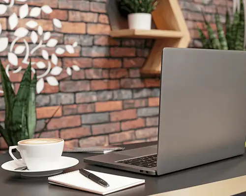 Modern Office Laptop Mockup With Sticker On Gray Surface Coffee Cup And Notepad Scene 0111