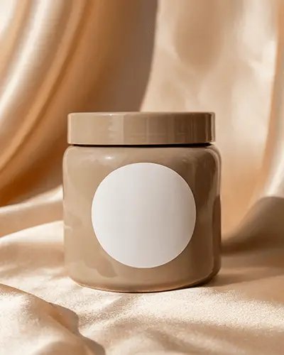 Cosmetic Jar Sticker Mockup On Glossy Beige Container With Round Label And Satin Drape Background 0187