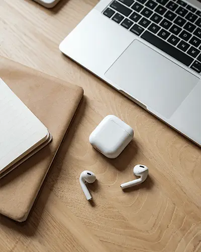 Premium Wooden Desk Featuring Notebook Laptop Sticker Mockup With Earbuds Charging Case